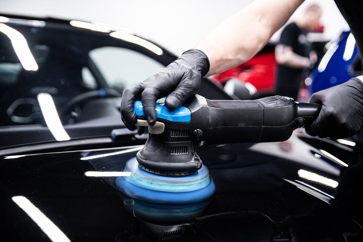 Detailing specialist polishing vehicle paint by hand